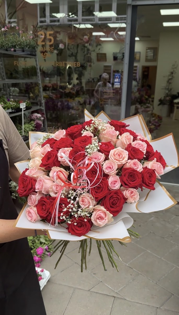 Großer roter und rosa Rosenstrauß vor dem Ladengeschäft